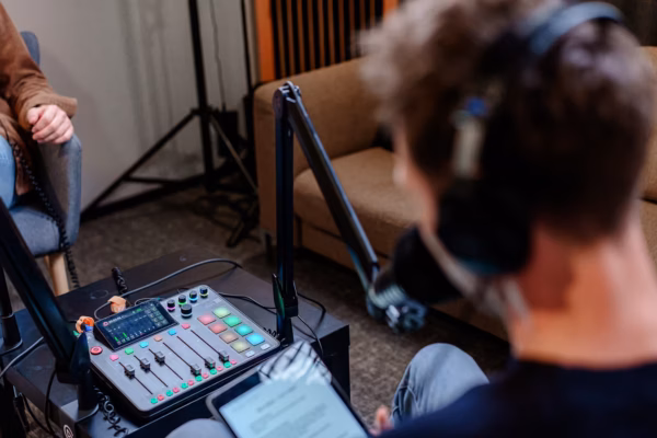 Podcast Studio - Stuttgart center 4 Ein Mischpult und eine Person mit Kopfhörern in einem Podcaststudio in Stuttgart Mitte.