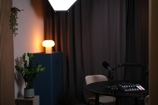 Modernes Podcaststudio im Zentrum von Stuttgart mieten mit rundem Aufnahmetisch, professionellem Mikrofon, Mischpult, Kopfhörern und akustisch optimiertem Raum.